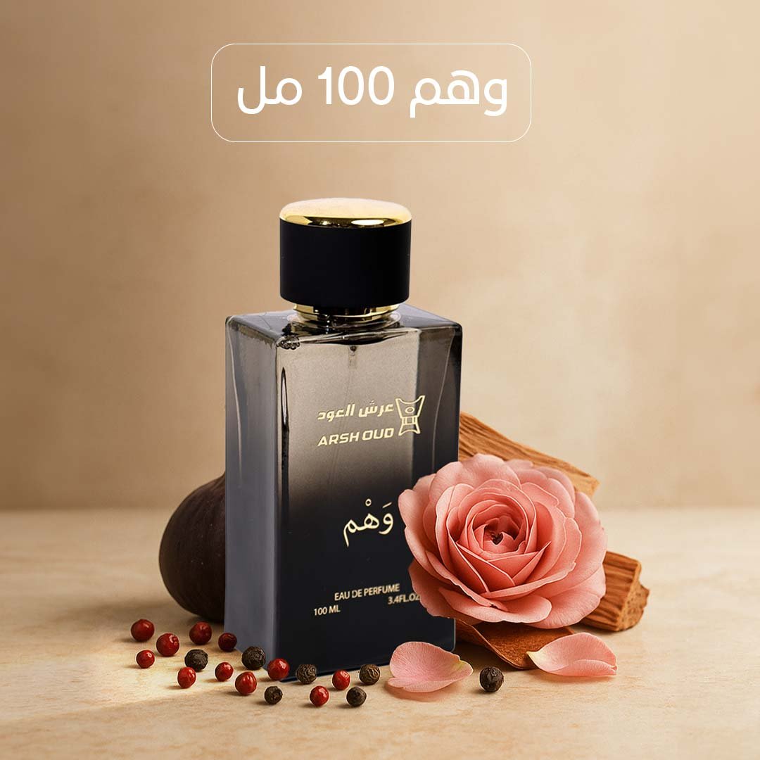 زجاجة عطر وهم 100 مل من عرش العود موضوعة على سطح خشبي، بجانب وردة وردية وحبوب فلفل، في تصميم أنيق وناعم.